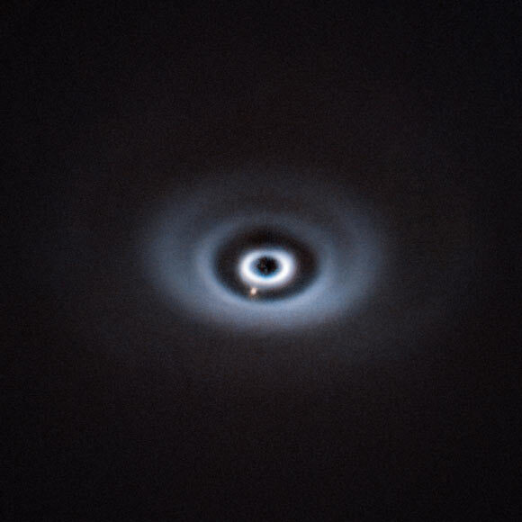 天文学家在类年轻太阳恒星周围的星盘空隙中发现正在成长的原行星的配图
